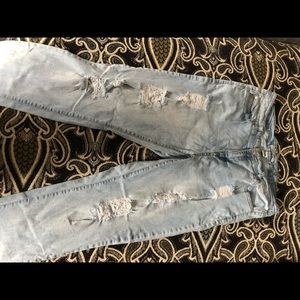 Light wash blue denim jeans w/ rips down the leg